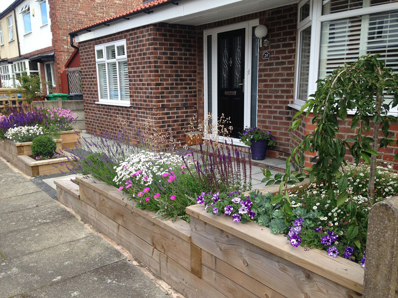 Wooden planters made from sleepers form the front garden